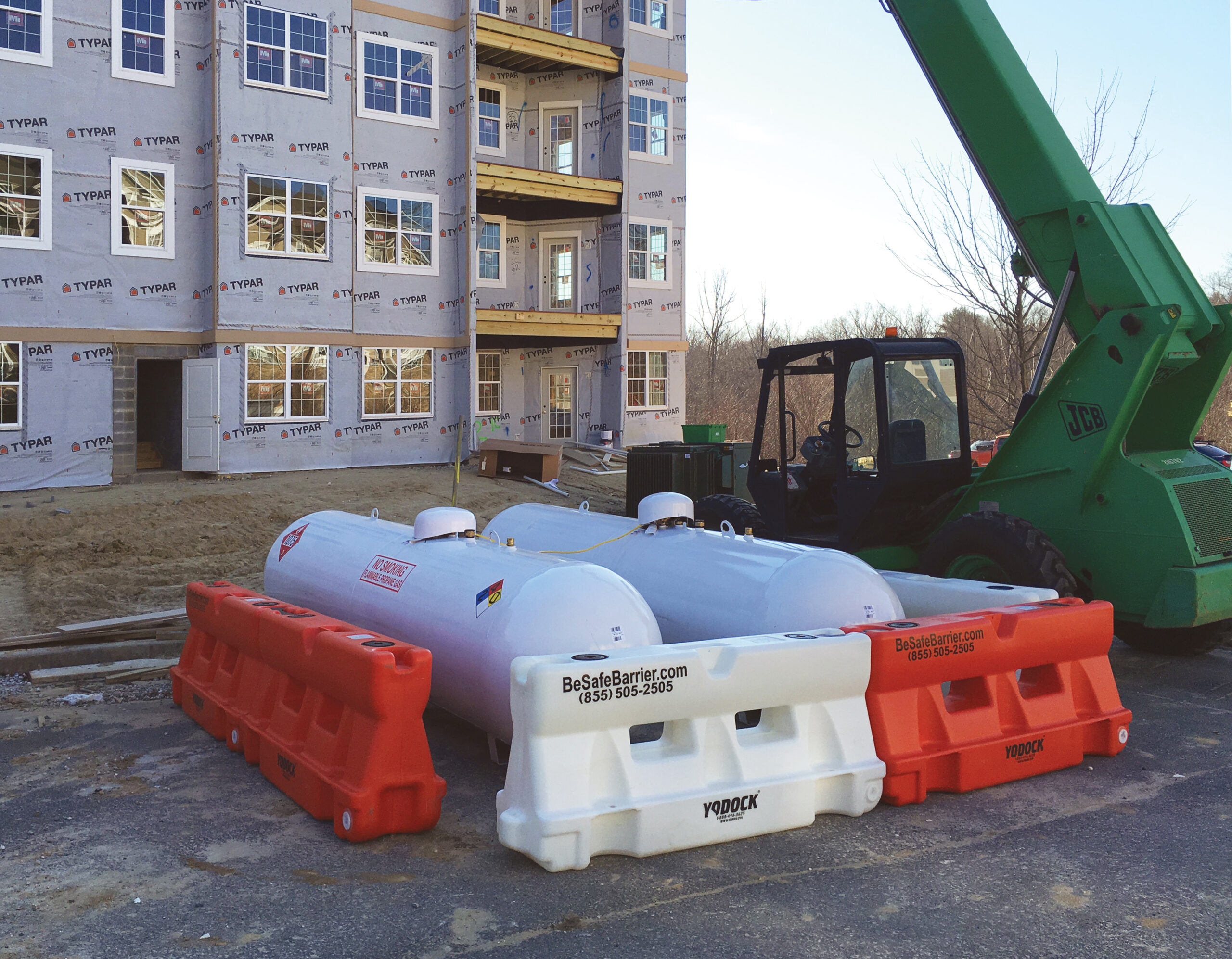 Bulk propane tanks being protected by Barriers at construction site