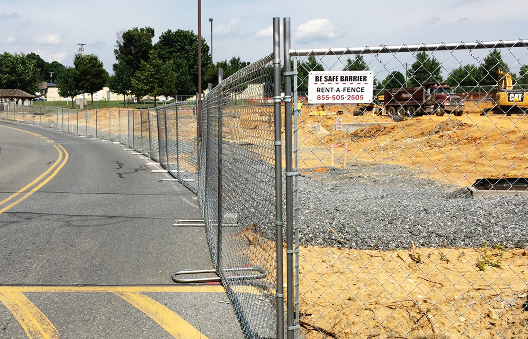 large construction site bounded by panel fence