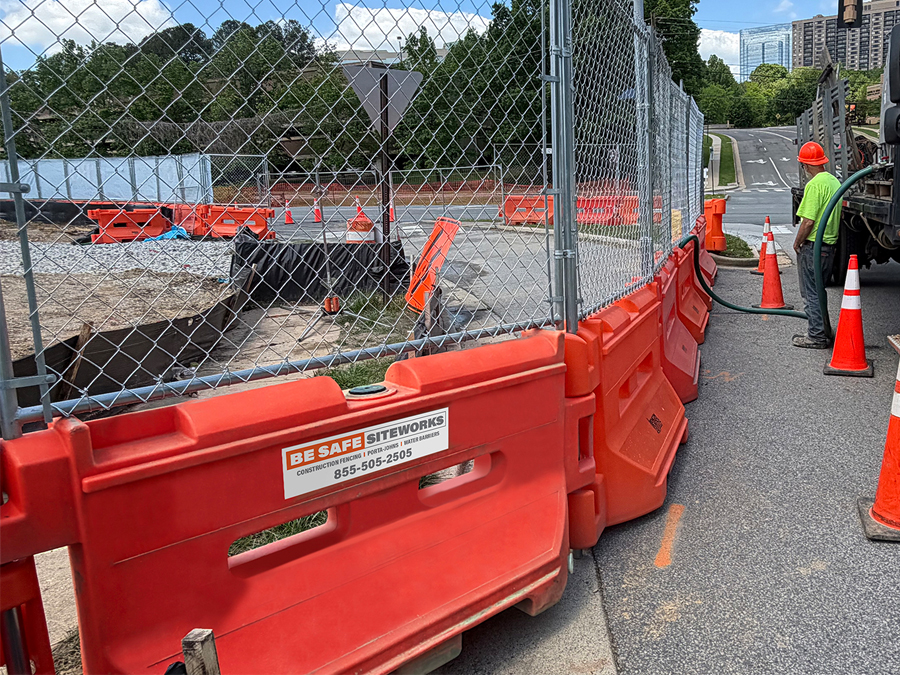 Barriers w fence-sm water-filler barriers with fence on top surround construction site